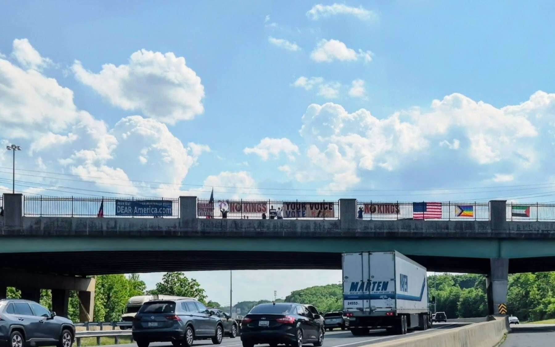 DEAR America banners and democracy signs displayed on a Harford County overpass.