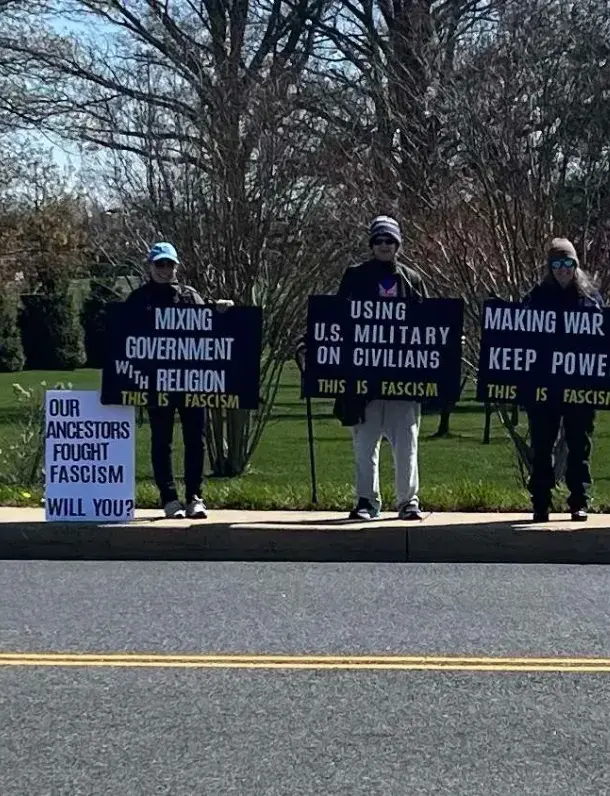 Volunteers holding Signs of Fascism protest signs along a Harford County road.